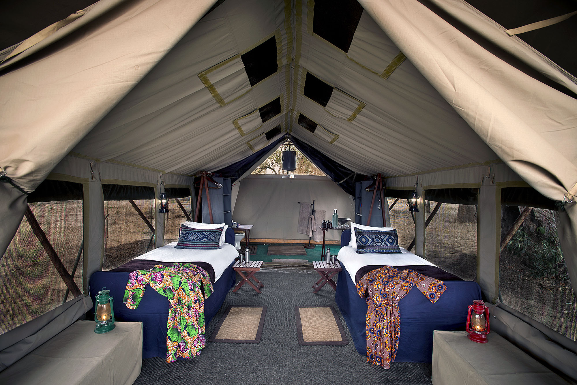 Komfortabel eingerichtetes Safari-Zelt mit Einzelbetten in einem exklusiven Wildnis-Camp in Afrika.